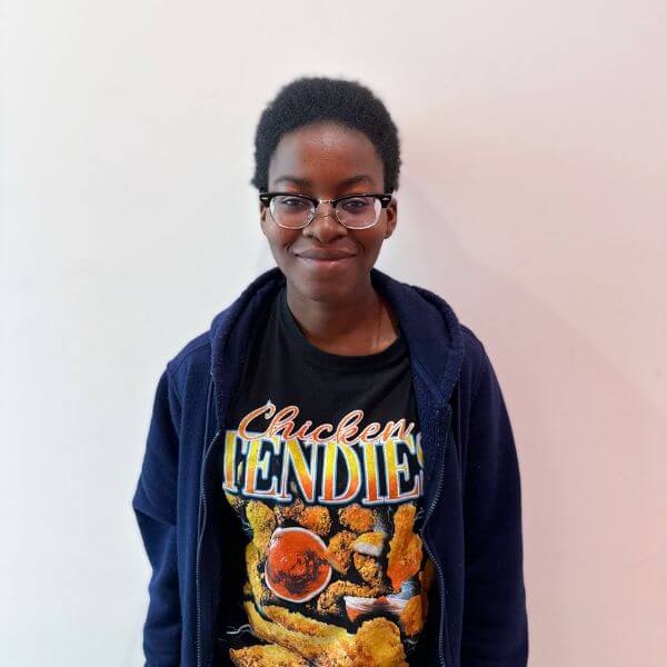 A student smiling with glasses against a white backdrop