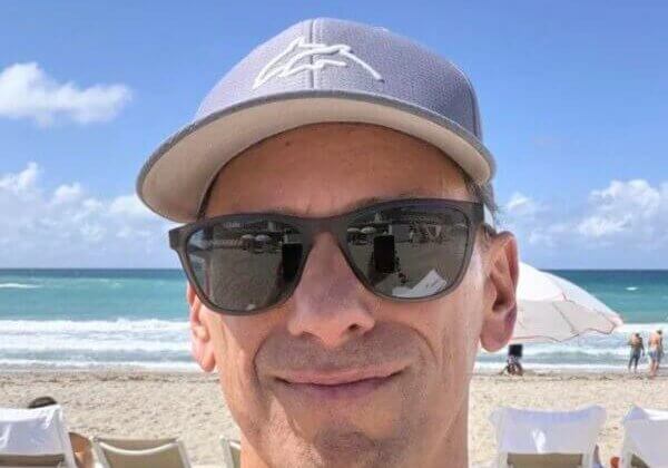 Man in sunglasses smiling at the beach